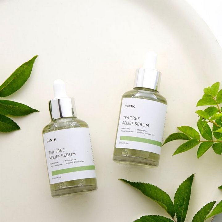 Två flaskor med iUNIK Tea Tree Relief Serum 50ml speciellt framtagen för aknebenägen och känslig hud på en vit platta.