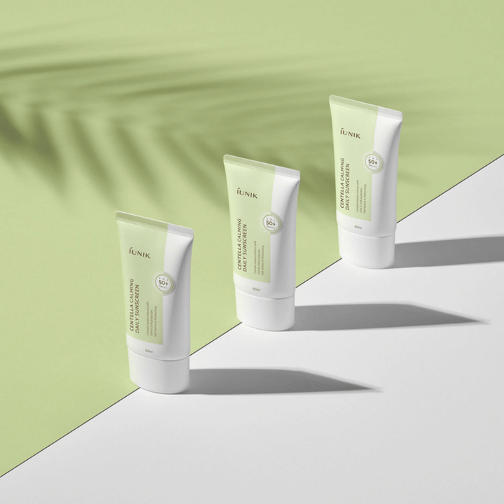 Tre tuber iUNIK Centella Calming Daily Sunscreen med SPF 50+ skydd mot UVA- och UVB-strålar på vit bakgrund.