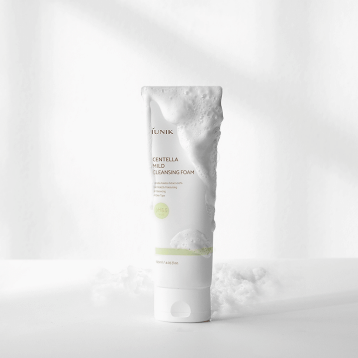 En tub iUNIK Centella Mild Cleansing Foam 120ml med salicylsyra och centella asiatica-extrakt sittande på ett vitt bord.